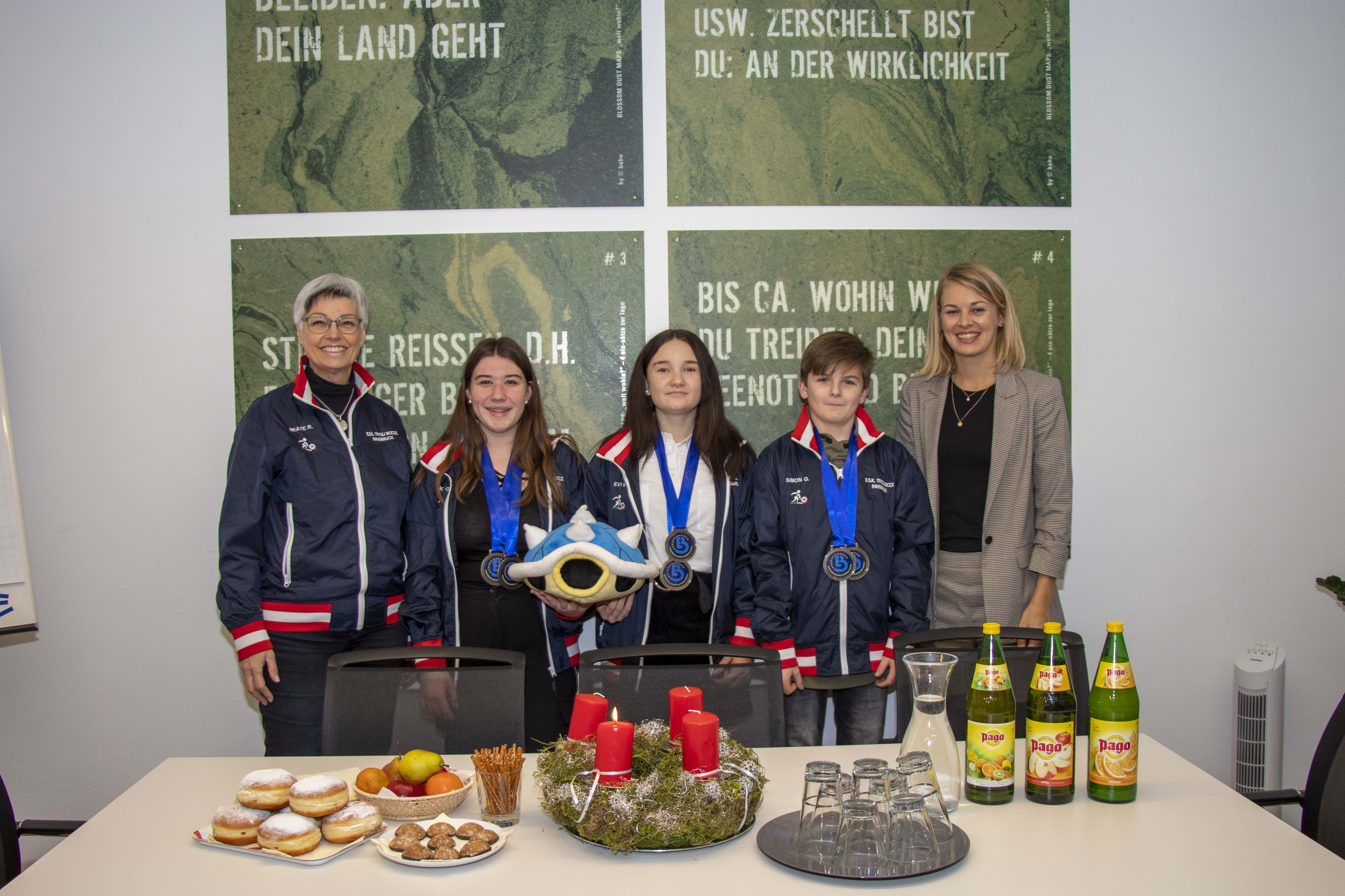 Innsbrucker Nachwuchstalente vom ESK Tivoli konnten bei der Boccia-Junioren-Europameisterschaft im deutschen Gersthofen vier Medaillen erobern. Grund genug die doppelten Bronzemedaillen-GewinnerInnen ins Rathaus einzuladen. Die für Sport verantwortliche Stadträtin Elisabeth Mayr (r.) gratulierte der Trainerin Beate Reinalter und den SportlerInnen Evi Werth, Sonja Gleißner und Simon Gadner (v.l.) zum Medaillenregen. In gemütlicher Atmosphäre, bei Fruchtsaft, Keksen und Faschingskrapfen, erzählten die Jugendlichen von ihrer erfolgreichen Europameisterschaft, von den vielen Freunden, die sie kennen gelernt haben und von ihrem Maskottchen „Schischkröte“, welches zusammen mit den mitgereisten Familien und vielen anderen Fans wesentlich zum Erfolg beigetragen hat.
Für ihre sportlichen Leistungen überreichte Stadträtin Mayr den erfolgreichen Medaillen-GewinnerInnen auch ein kleines Geschenk.