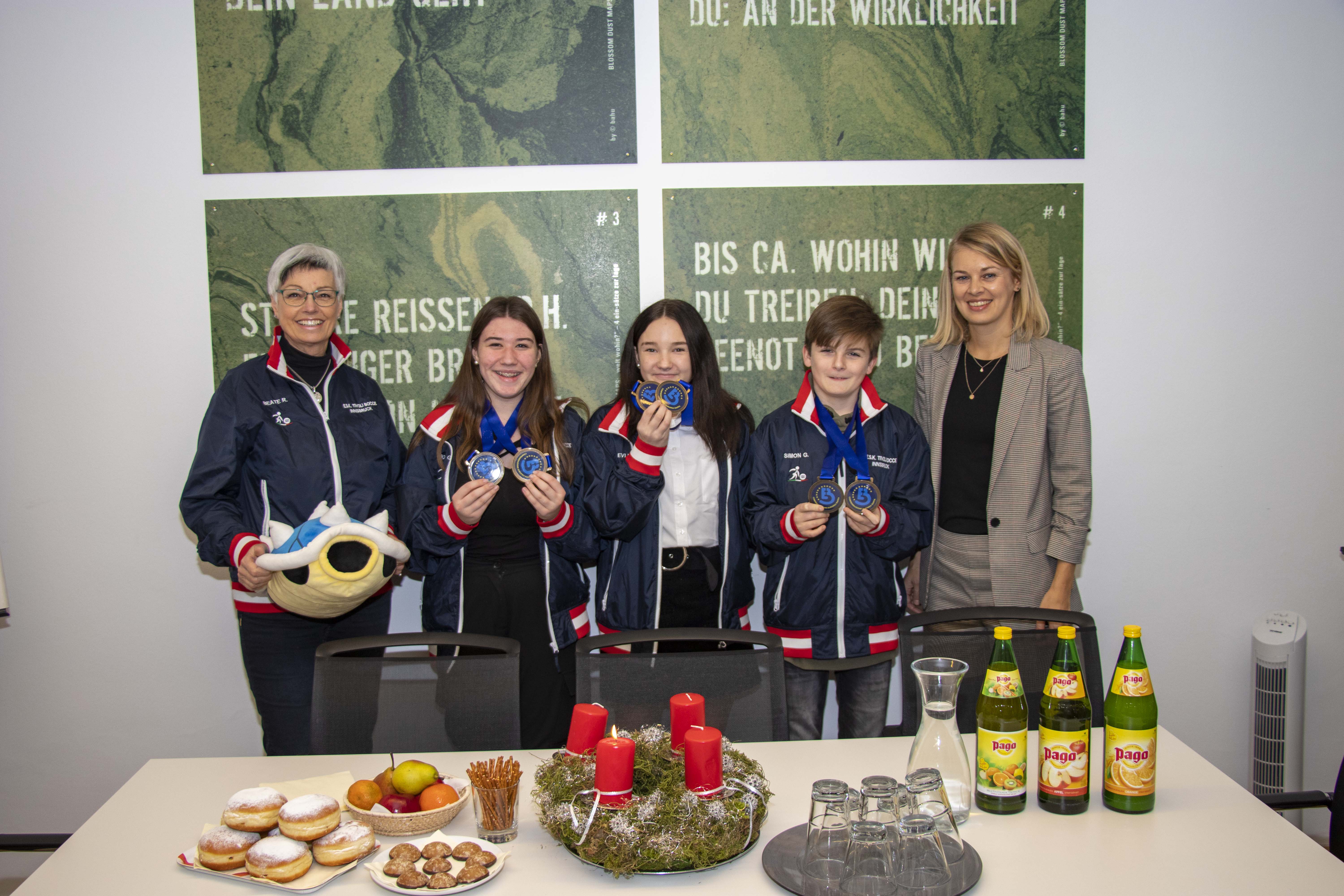 Innsbrucker Nachwuchstalente vom ESK Tivoli konnten bei der Boccia-Junioren-Europameisterschaft im deutschen Gersthofen vier Medaillen erobern. Grund genug die doppelten Bronzemedaillen-GewinnerInnen ins Rathaus einzuladen. Die für Sport verantwortliche Stadträtin Elisabeth Mayr (r.) gratulierte der Trainerin Beate Reinalter und den SportlerInnen Evi Werth, Sonja Gleißner und Simon Gadner (v.l.) zum Medaillenregen. In gemütlicher Atmosphäre, bei Fruchtsaft, Keksen und Faschingskrapfen, erzählten die Jugendlichen von ihrer erfolgreichen Europameisterschaft, von den vielen Freunden, die sie kennen gelernt haben und von ihrem Maskottchen „Schischkröte“, welches zusammen mit den mitgereisten Familien und vielen anderen Fans wesentlich zum Erfolg beigetragen hat.
Für ihre sportlichen Leistungen überreichte Stadträtin Mayr den erfolgreichen Medaillen-GewinnerInnen auch ein kleines Geschenk.
