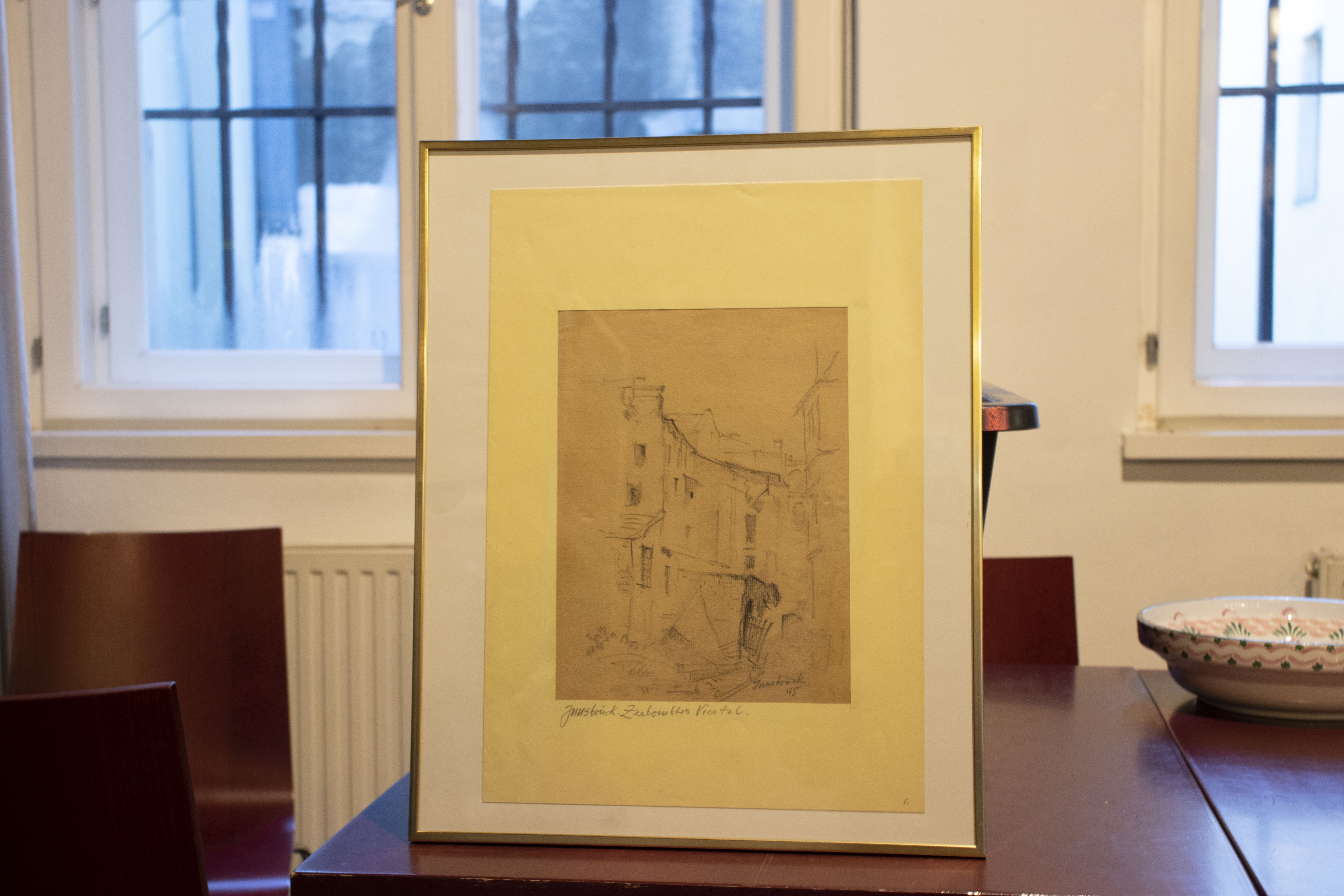 Ein besonderes Geschenk erhielt Bürgermeister Georg Willi (r.) von Bischof Hermann Glettler (l.): Eine Zeichnung des Innsbrucker Künstlers Wilhelm Nicolaus Prachensky (1898-1956). Der Bürgermeister gab das Werk an das Stadtarchiv/Stadtmuseum Innsbruck unter der Leitung von Lukas Morscher (M.) weiter. Es zeigt die Zerstörung der Innsbrucker Altstadt durch den Zweiten Weltkrieg. Während der Dom zu St. Jakob schwer getroffen wurde, blieb der Großteil der Wahrzeichen wie das Goldene Dachl, der Stadtturm, die Hofburg, das Helblinghaus oder die Ottoburg weitgehend von Bombenschäden verschont.