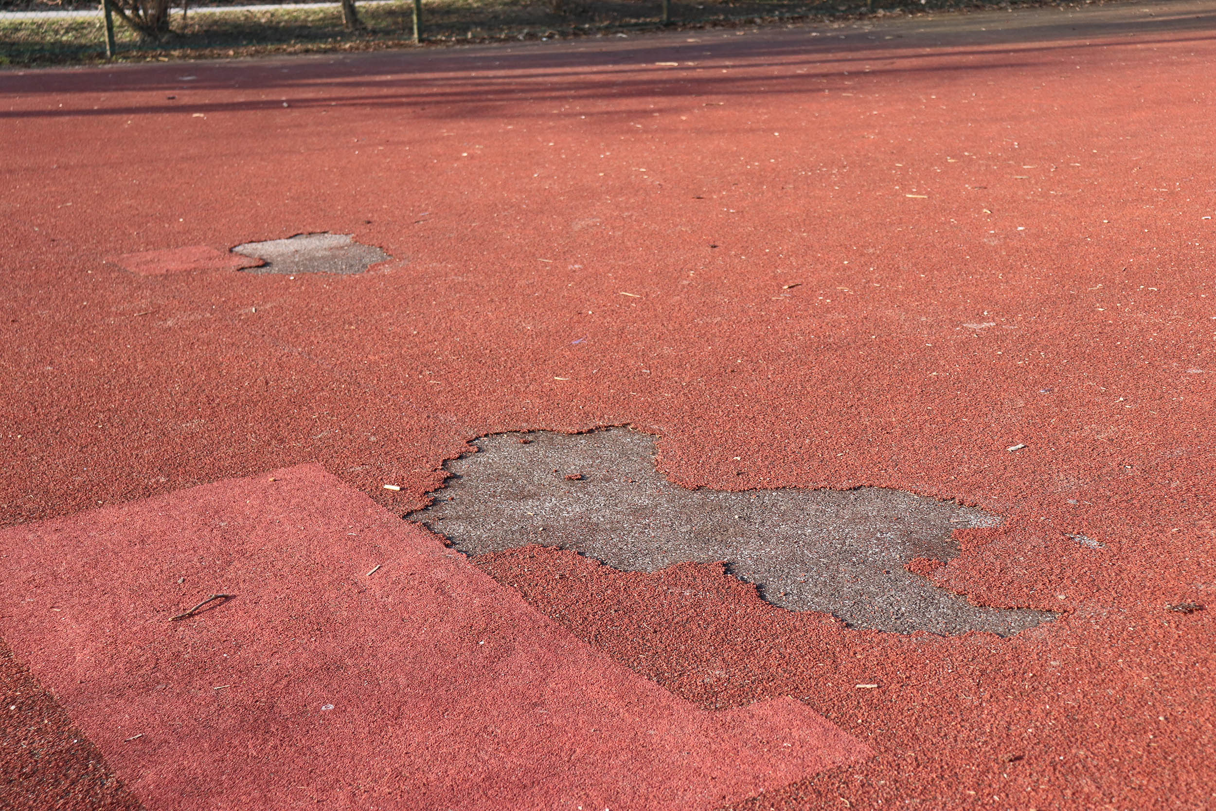 Belagschäden sind am Platz an mehreren Stellen zu finden.