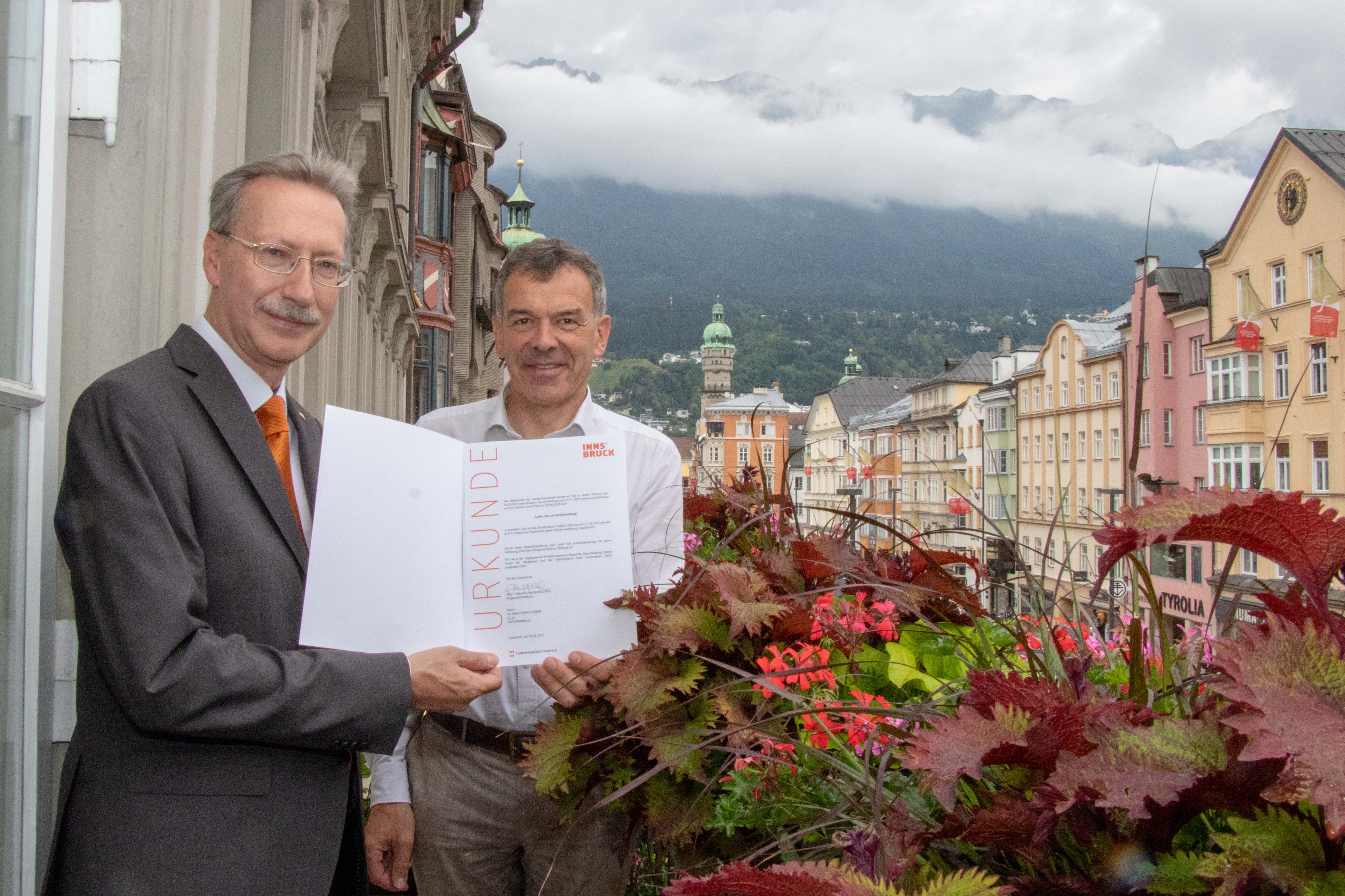 Dr. Hans Fankhauser wurde vom Stadtsenat und Gemeinderat für weitere fünf Jahre als Leiter der Kontrollabteilung der Stadt Innsbruck bestellt. Bürgermeister Georg Willi (r.) übergab ihm dafür eine Weiterbestellungsurkunde. Gleichzeitig sprach er seinen Dank für die bisher erbrachten Leistungen aus und unterstrich die fachliche und soziale Kompetenz des Kontrollabteilungsleiters.