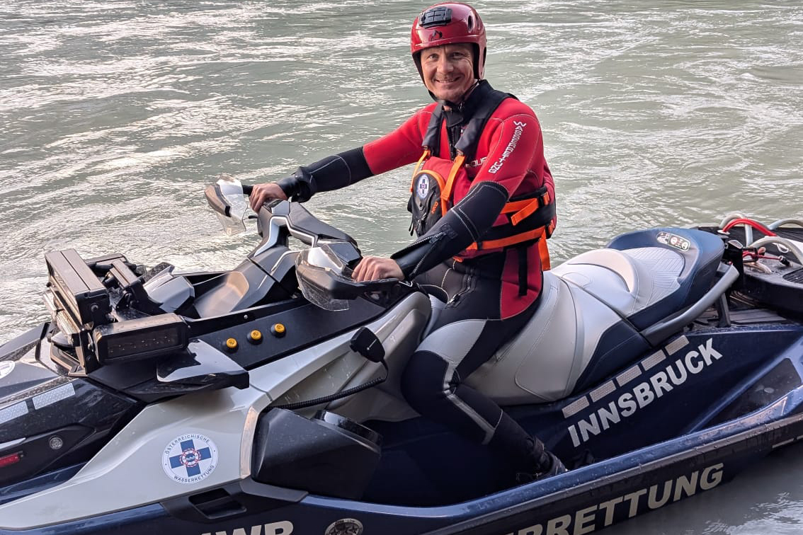 Bei einer beeindruckenden Trainingseinheit der Innsbrucker Wasserrettung stürzten sich 22 Rettungskräfte in die Herausforderungen des schmelzwasserführenden, reißenden Inns. Dabei standen nicht nur Sprünge von den Innbrücken auf dem Programm, sondern auch das Üben von Rettungstechniken sowie Fahrten mit dem neuen Jetski der Wasserrettung. Mitten im Geschehen: Innsbrucks Bürgermeister Johannes Anzengruber, der an dieser Übung teilnahm. „Dank des neuen Jetskis ist unsere Wasserrettung binnen kürzester Zeit am Einsatzort. Gerade bei Wasserunfällen zählt jede Sekunde. Bei der Trainingseinheit konnte ich mich von der beeindruckenden Leistungsfähigkeit dieses ausschließlich ehrenamtlich tätigen Teams überzeugen“, berichtete Anzengruber. Das Stadtoberhaupt testete die Leistungsstärke des neuen Rettungsfahrzeugs selbst auf dem Inn. Mit einer Maximalgeschwindigkeit von 110 km/h ermöglicht der Jetski schnelle Rettungseinsätze. Bereits seit rund 20 Jahren setzen die Tiroler am Inn erfolgreich auf diese Technik, und allein in diesem Jahr gab es schon 60 Einsätze.